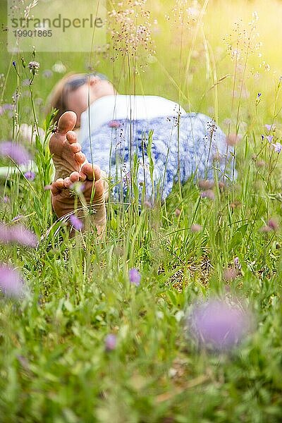 Junges Mädchen im Park liegt im Gras und genießt den Tag