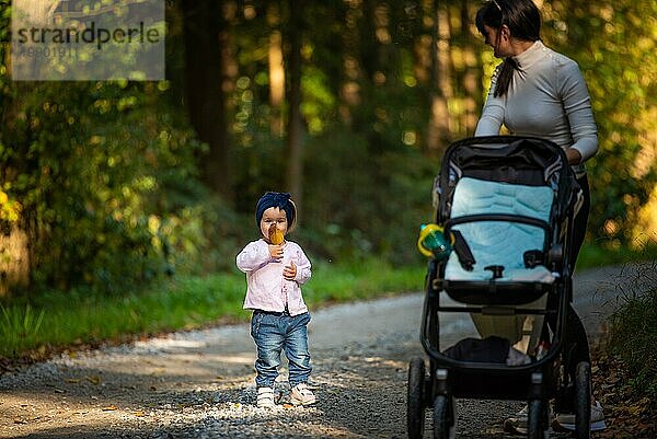 Mutter mit 12 Jahre altem Baby bei einem Spaziergang im Wald. Herbsttag. Waldlandschaft