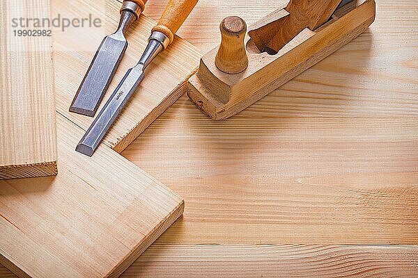 Old fashioned woodworkers plane carpentry chisel and wooden planks construction concept