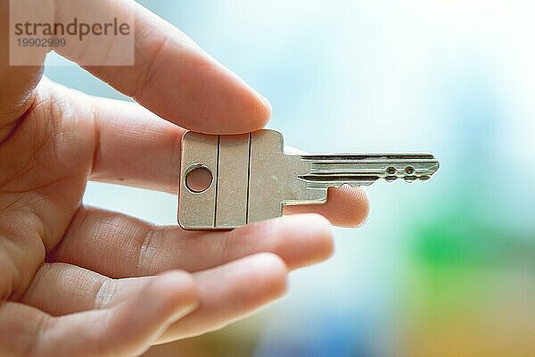 Einen Hausschlüssel in der Hand halten: Neues Zuhause und Eigentum