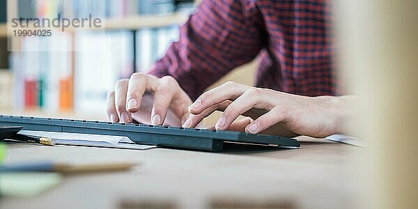 Tippende Hände auf der Tastatur  Heimbüro mit Textfeld