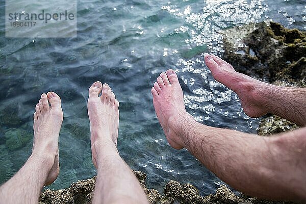 Beine von zwei Männern am Strand  entspannen