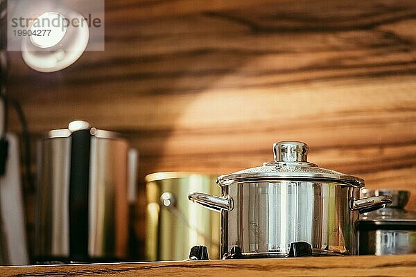 Dampfender Metalltopf in der Küche  Holz