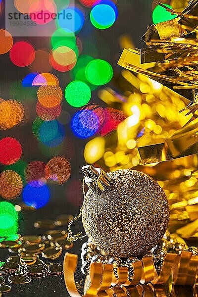 Gold Weihnachtskugel auf dem Hintergrund der dunklen Bokeh