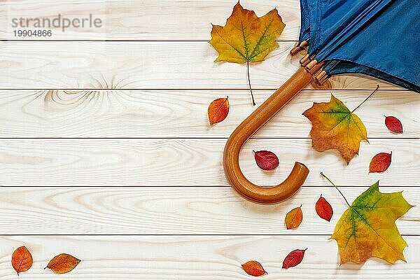 Herbst flach legen mit Blättern und Regenschirm auf Holz Hintergrund