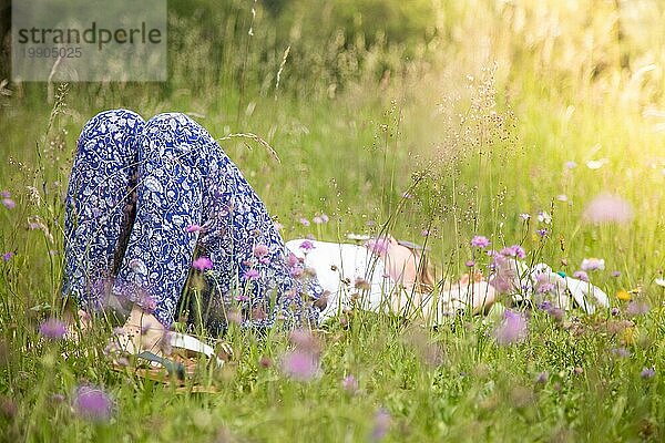 Junges Mädchen im Park liegt im Gras und genießt den Tag