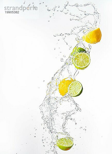 Frische Limetten und Zitronen mit Wasser spritzen in der Luft  vor weißem Hintergrund. Erfrischung Konzept
