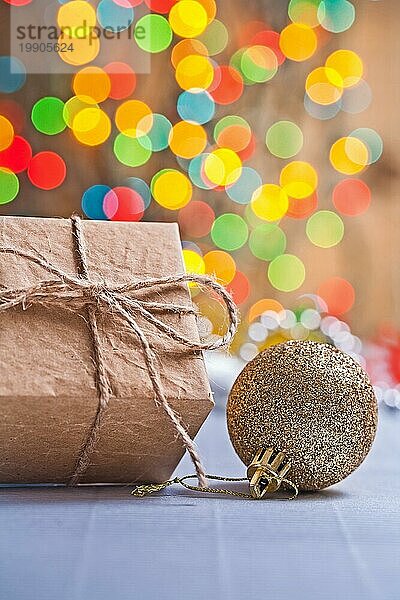 Vintage Papier Geschenkbox und goldfarbenen Weihnachtskugel auf unscharfen Hintergrund