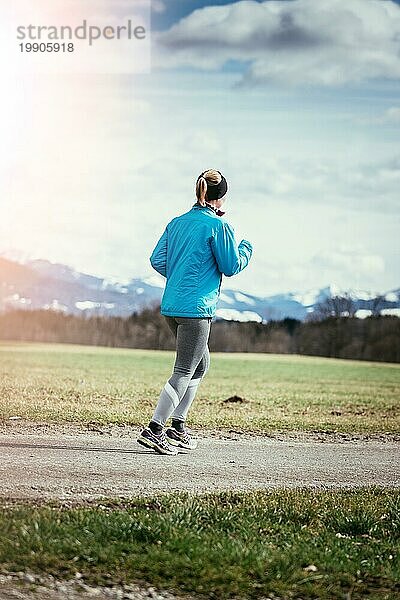 Junge Frau joggt  Landschaft