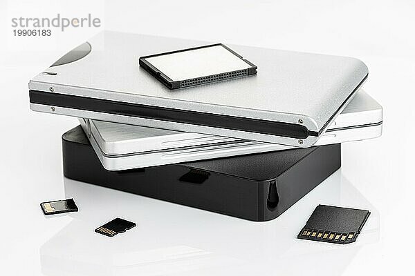 Gruppe von externen Festplatten und Speicherkarten auf weißem Tisch. Konzept der Datenspeicherung