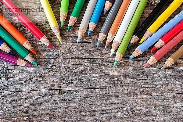 Satz mehrfarbiger Bleistifte auf einem rustikalen Holztisch  Kopierraum