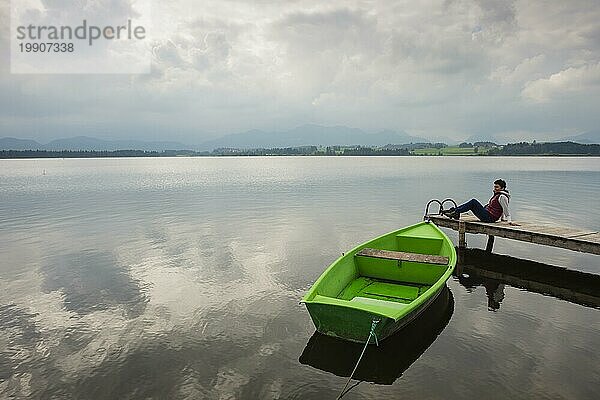 Frau  Holzsteg  grünes Ruderboot  Hopfensee  Hopfen am See  bei Füssen  Ostallgäu  Allgäu  Bayern  Deutschland  Europa