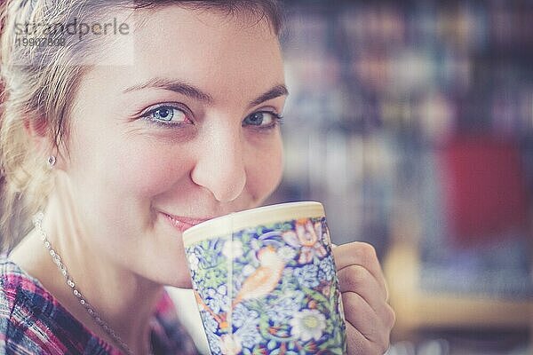 Schöne junge Frau genießt eine Tasse Tee