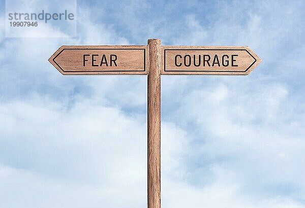 Furcht oder Mut Konzept. Worte in entgegengesetzte Richtungen auf Wegweiser mit Himmel Hintergrund