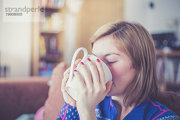 Schöne junge Frau genießt eine Tasse Tee