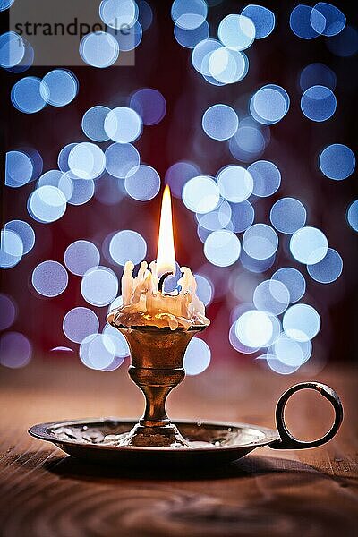 Brennende Kerze in Vintage Messing Kerzenhalter stehen auf alten Holzbrett