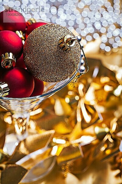 Weihnachtskugeln gold und rot im Weinglas