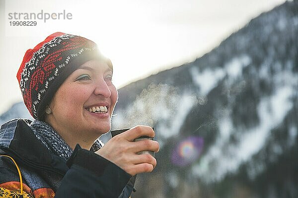 Schönes kaukasisches Mädchen hält eine Tasse Tee im Freien  Winterzeit