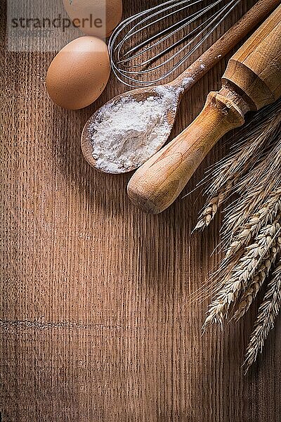 Geordneter Kopierraum Eier Blumenkrone Löffel mit Mehl Nudelholz Weizenähren auf Holzbrett Essen und Trinken Stillleben
