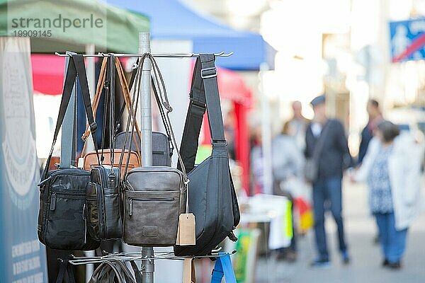Verschiedene Taschen  Geldbeutel und Handtaschen auf einem Flohmarkt  Menschen im unscharfen Hintergrund