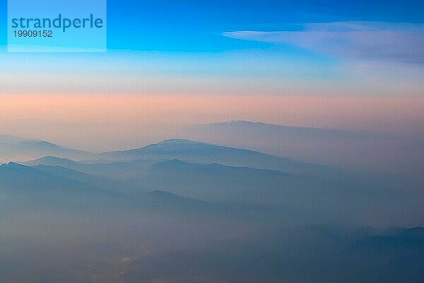 Luftaufnahme von rosa und blaün Sonnenuntergang  Sonnenaufgang über Berge Silhouetten  Schuss aus dem Flugzeug