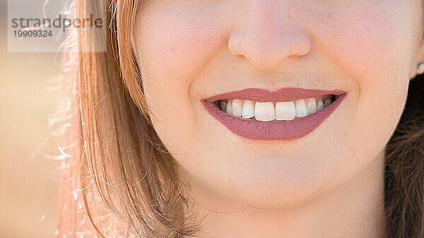 Schönes Mädchen mit kirschroten Lippen und weißen Zähnen lächelt