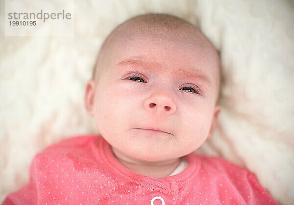 Neugeborenes mit sehr traurigem Gesicht beginnt zu weinen. Baby Gesundheitspflege