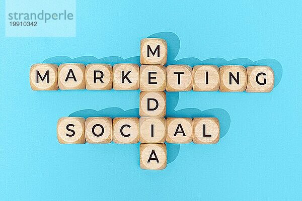 Social Media Marketing Wörter auf Holzblöcken auf blauem Hintergrund. Ansicht von oben