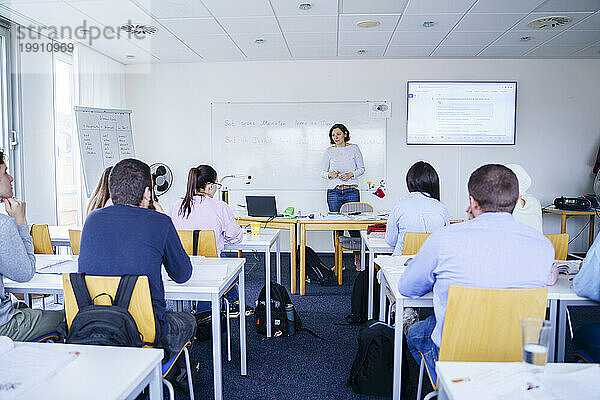 Frau unterrichtet multiethnische Schüler im Klassenzimmer