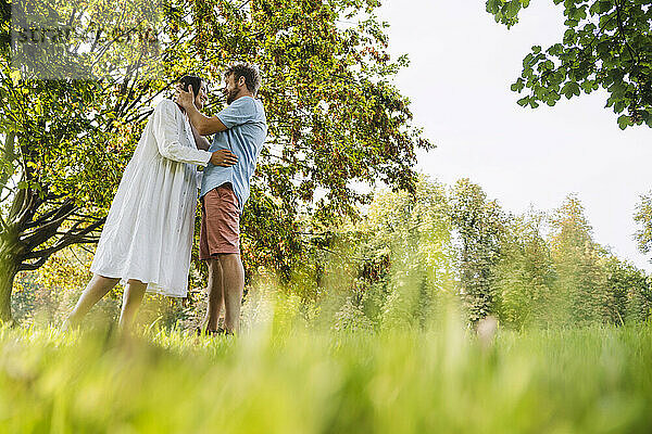 Romantisches Paar steht auf Gras im Park