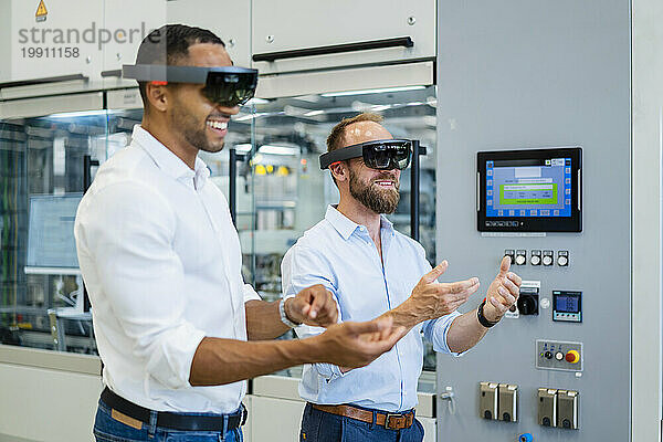 Zwei Techniker mit Augmented-Reality-Brille in einer Fabrik und gestikulieren