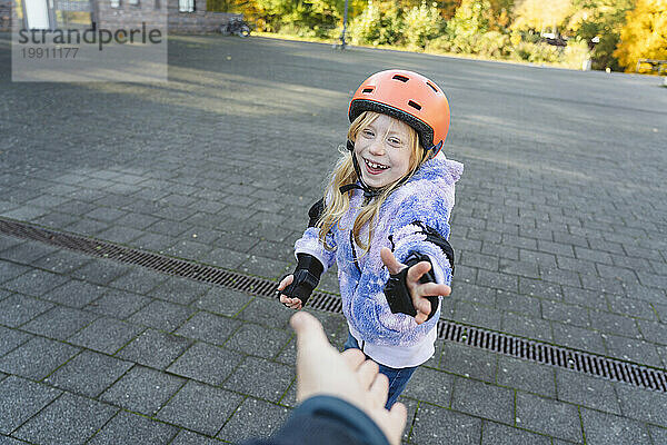 Fröhliches Mädchen mit Helm gibt der Mutter ein High-Five