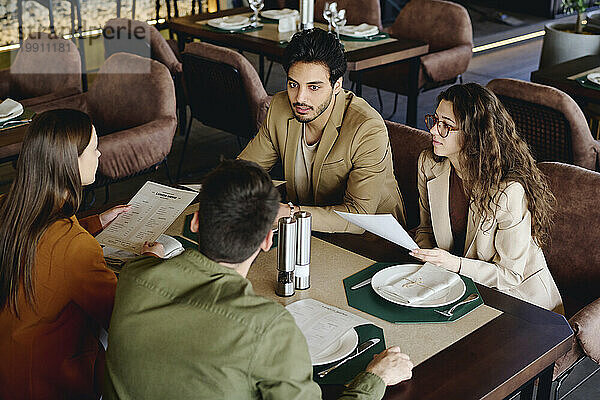 Geschäftskollegen diskutieren über die Speisekarte im Restaurant