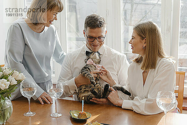 Happy family celebrating cat's birthday at home