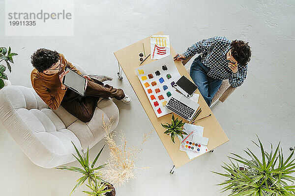 Graphic designers planning together sitting at desk in office