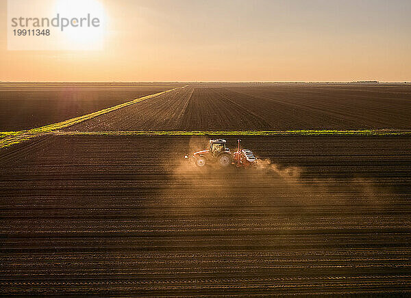Serbien  Provinz Vojvodina  Luftaufnahme eines Traktors  der bei Sonnenuntergang Samen sät