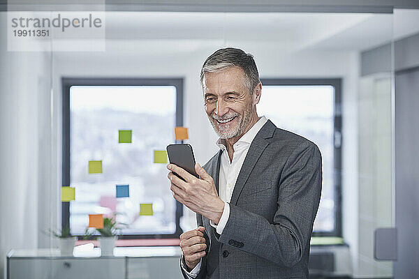 Happy senior businessman using mobile phone