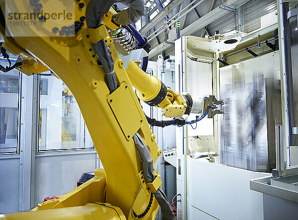 Yellow robotic arm in factory