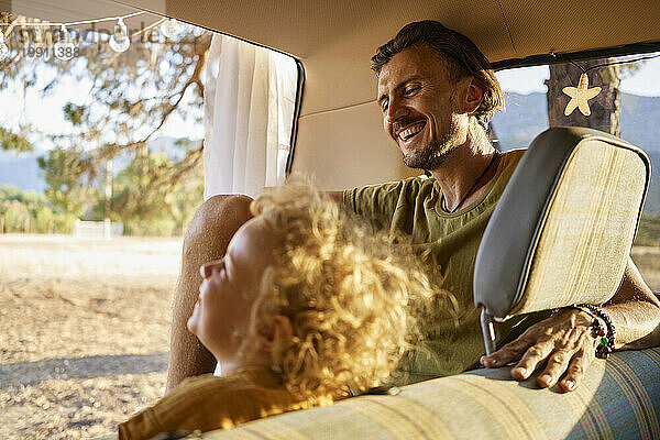 Vater lacht mit Tochter und verbringt Freizeit im Wohnwagen