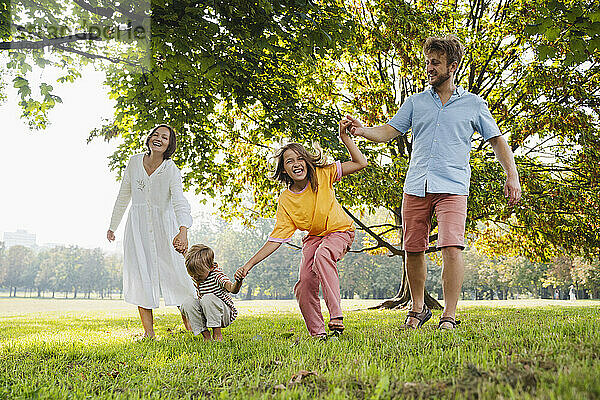 Glückliche Familie verbringt ihre Freizeit beim gemeinsamen Spielen im Park