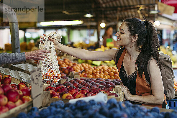 Frau kauft frisches Obst und Gemüse auf dem Stadtmarkt
