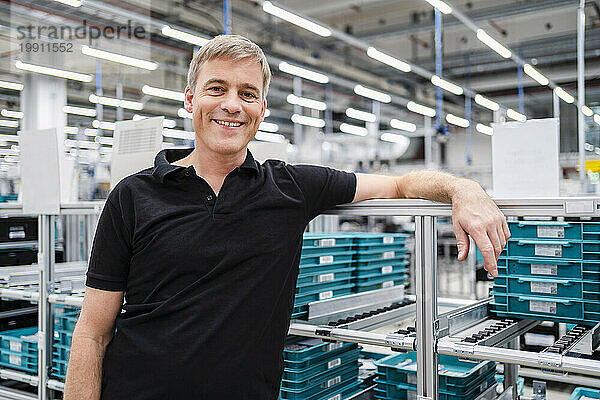 Porträt eines lächelnden Mitarbeiters in einer Fabrik