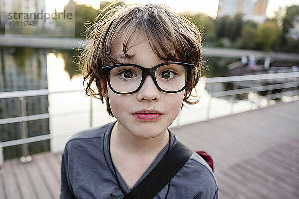 Netter Junge mit Brille auf Brücke