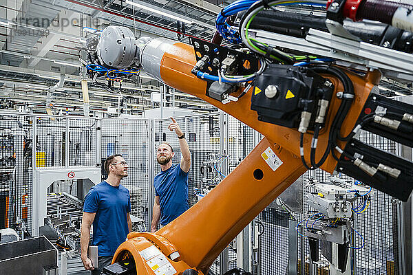 Zwei Techniker untersuchen Industrieroboter in einer Fabrik