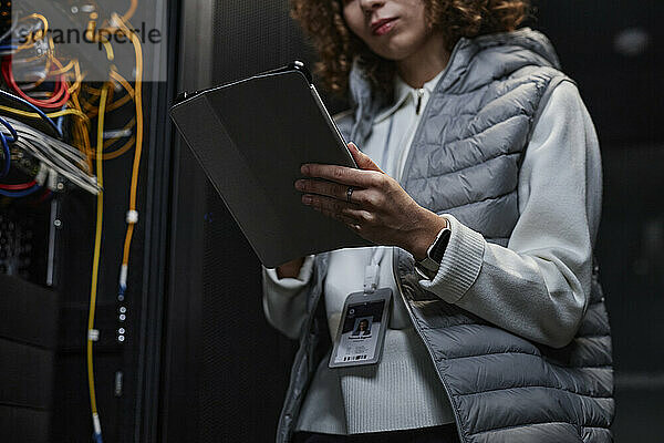 IT-Experte nutzt Tablet-PC und richtet Supercomputersystem im Datenbankraum ein