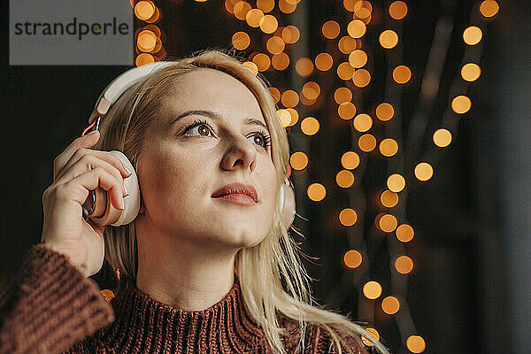 Schöne Frau mit blonden Haaren  die Musik über kabellose Kopfhörer hört