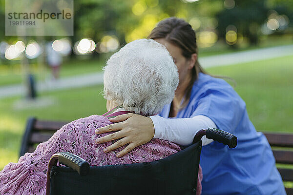 Gesundheitshelfer tröstet ältere Frau im Park