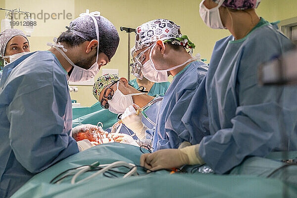 Team von Chirurgen und Krankenschwestern führt Operationen am Patienten im Operationssaal durch
