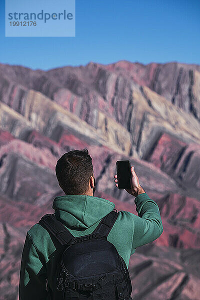 Mann fotografiert Berge mit Mobiltelefon