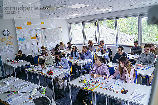 Multiethnische Schüler lernen am Schreibtisch im Bildungskurs